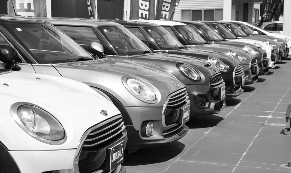 Citadine d'occasion grise stationnée en concession, carrosserie propre et pneus neufs
